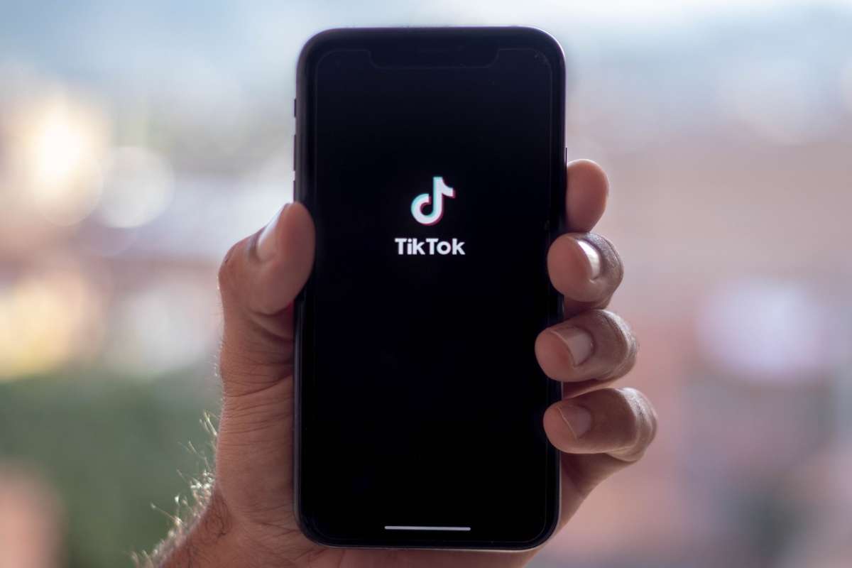 Uomo tiene in mano un telefono con l'app TikTok